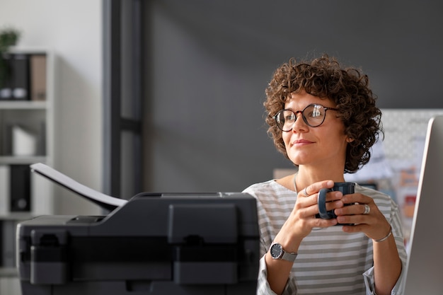 Tiro medio mujer sosteniendo la taza de café