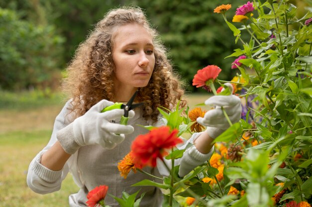 Tiro medio mujer sosteniendo tijeras de jardinería