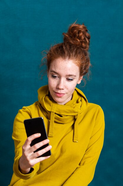 Foto gratuita tiro medio mujer con teléfono inteligente tomando una selfie