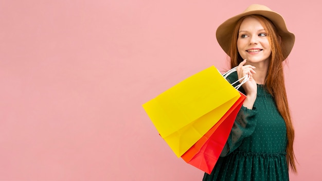 Foto gratuita tiro medio, mujer, tenencia, bolsas de compras