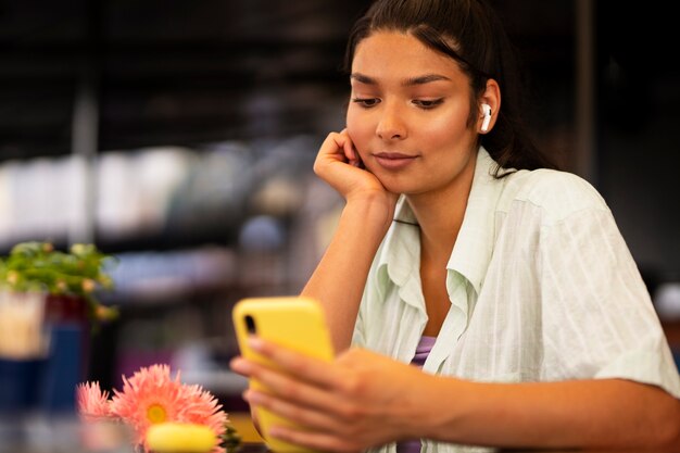 Tiro medio, mujer, tenencia, teléfono inteligente