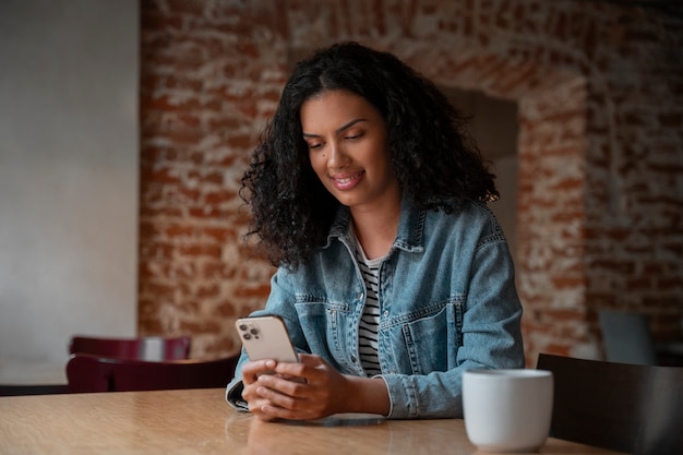 Tiro medio, mujer, tenencia, teléfono inteligente