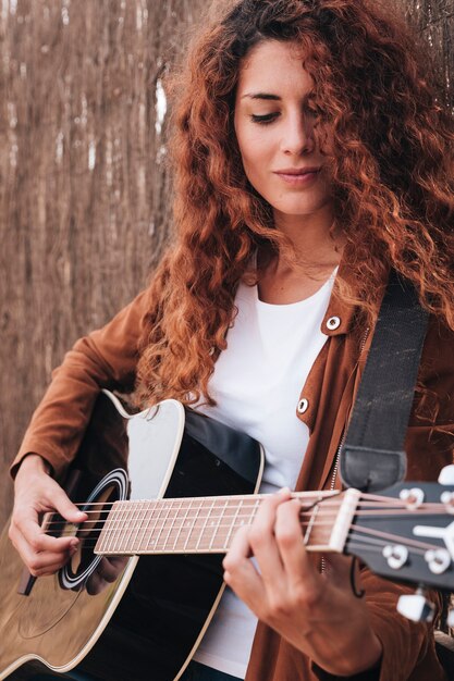 Tiro medio mujer tocando la guitarra