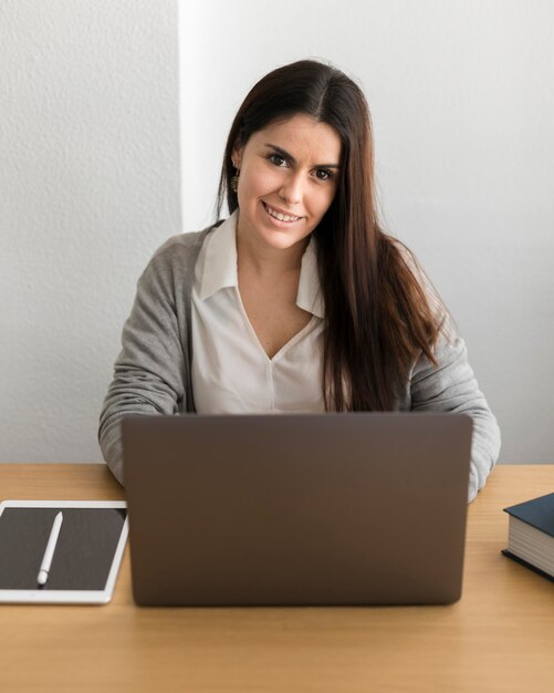 Tiro medio mujer trabajando en la computadora portátil