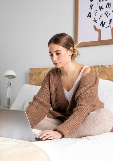 Foto gratuita tiro medio mujer trabajando en dormitorio