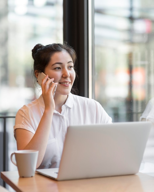 Tiro medio mujer trabajando en la mesa