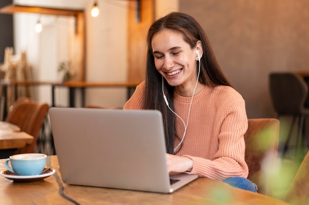 Foto gratuita tiro medio mujer usando audífonos