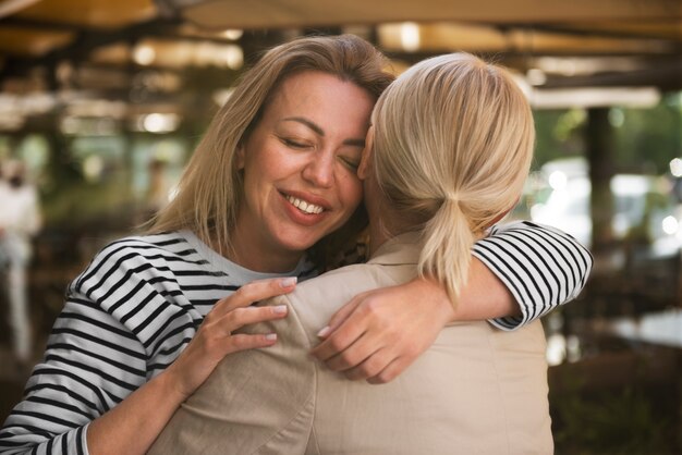 Tiro medio, mujeres felices, abrazar