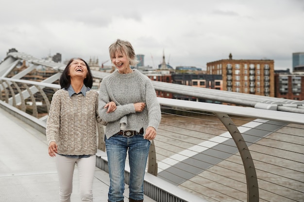 Foto gratuita tiro medio mujeres felices caminando juntos