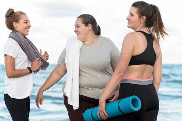 Tiro medio mujeres felices en la playa