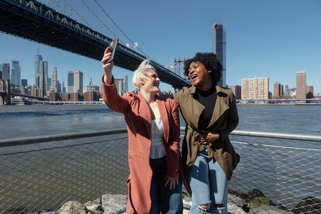 Tiro medio mujeres felices tomando selfie