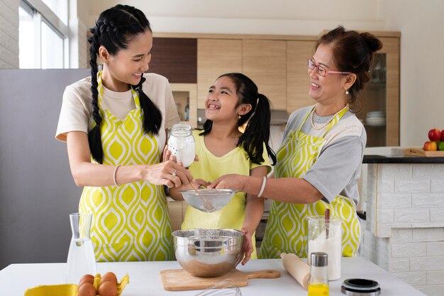 Tiro medio mujeres y niña cocinando