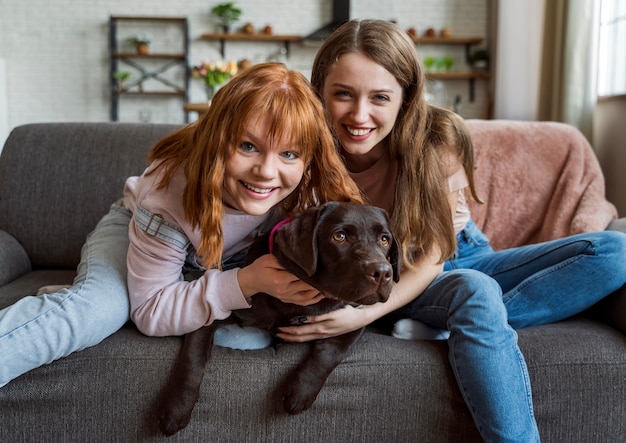 Tiro medio mujeres tendido con perro en el sofá