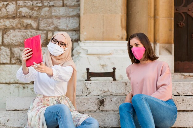 Tiro medio mujeres tomando selfie al aire libre