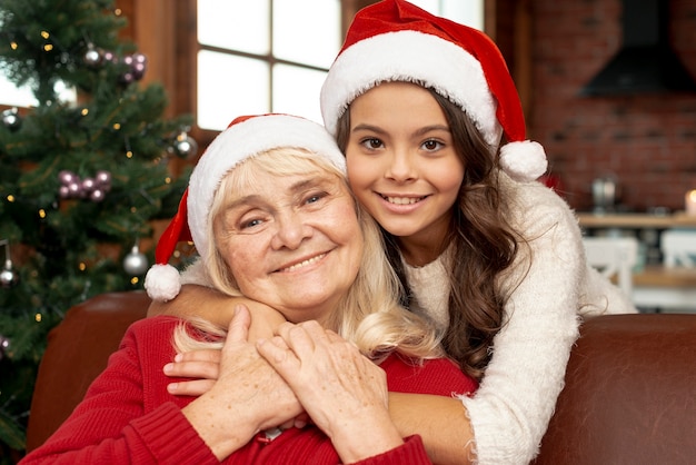 Tiro medio niña feliz abrazando a su abuela