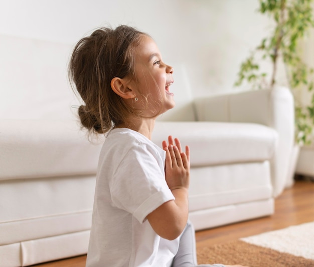 Foto gratuita tiro medio niña feliz meditando