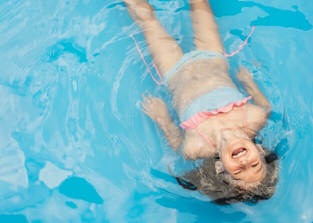 Tiro medio niña feliz en la piscina