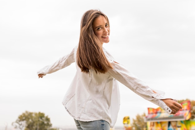 Foto gratuita tiro medio niña feliz posando al aire libre