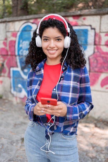 Tiro medio niña feliz posando con auriculares