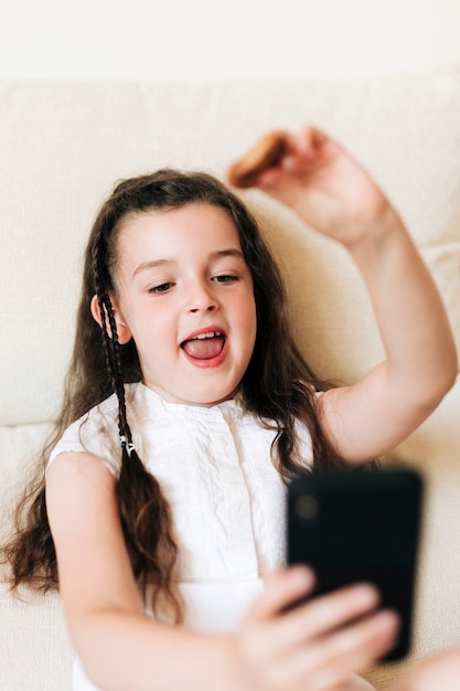 Tiro medio niña feliz tomando un selfie