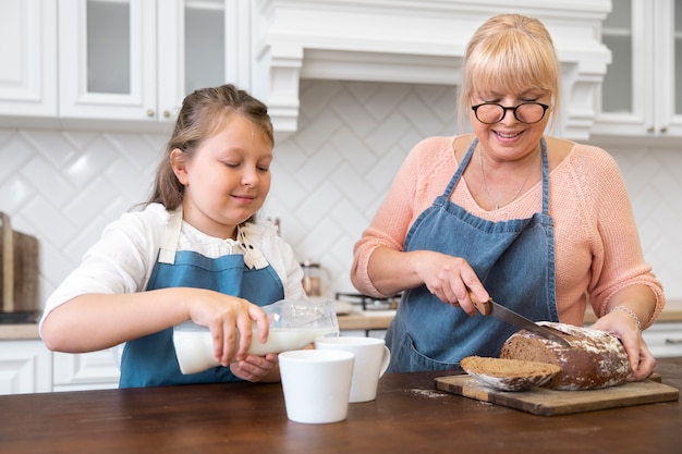 Tiro medio niña y mujer cocinando