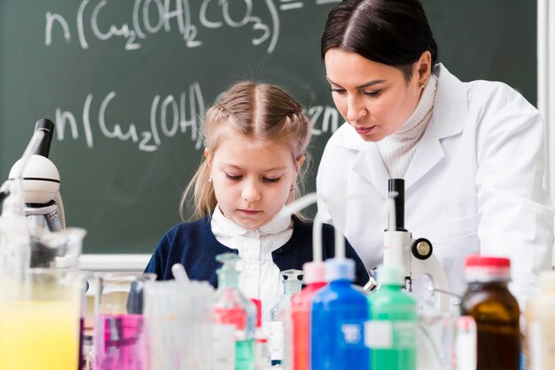 Tiro medio niña y mujer en laboratorio