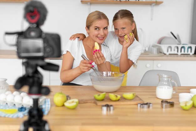 Tiro medio niña y mujer sosteniendo manzanas