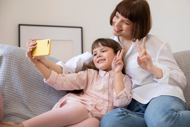 Tiro medio niña y mujer tomando autorretratos