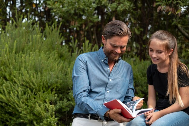 Tiro medio niña y padre leyendo