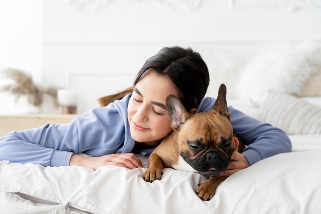 Tiro medio niña y perro en la cama