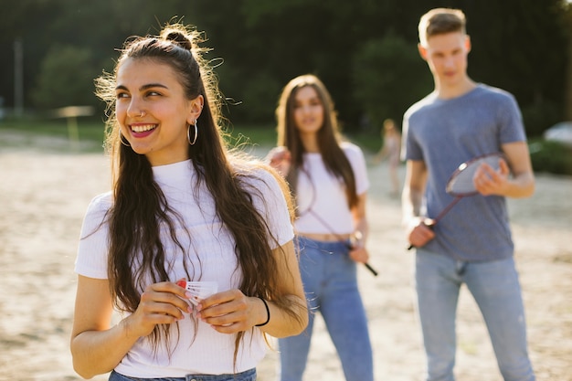 Tiro medio niña sonriente con amigos borrosos