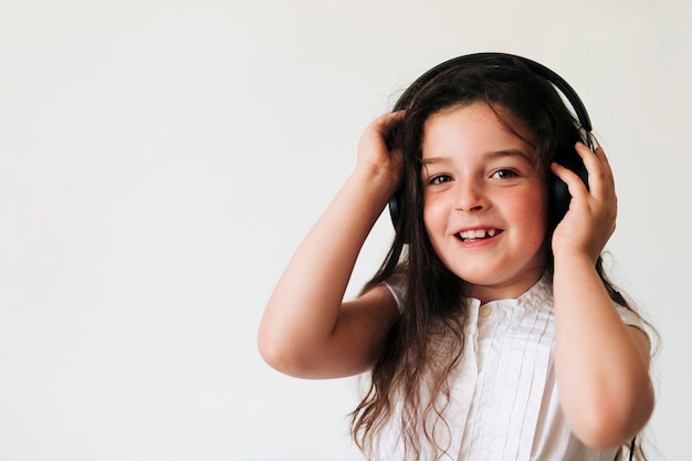 Tiro medio niña sonriente con auriculares