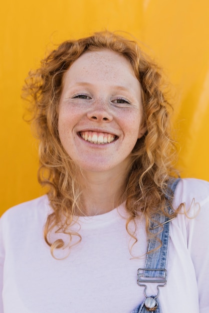 Tiro medio niña sonriente con fondo amarillo