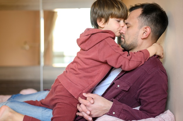 Tiro medio niño besando padre