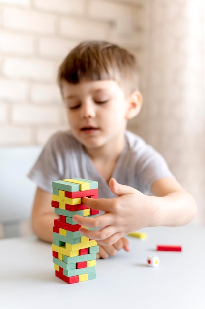 Tiro medio niño borroso con juego de jenga