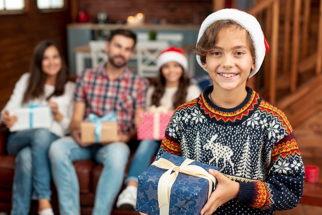 Foto gratuita tiro medio niño feliz con regalo de navidad