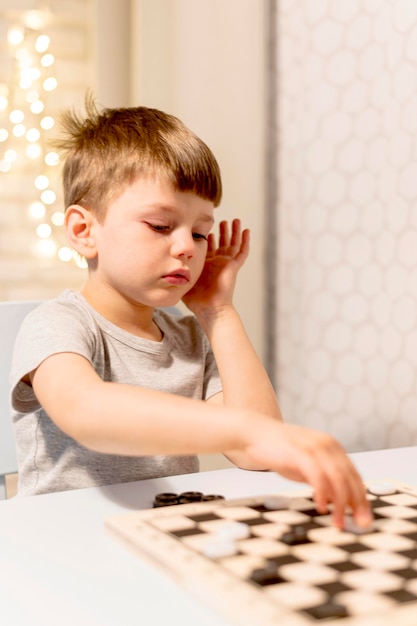 Tiro medio niño jugando al ajedrez