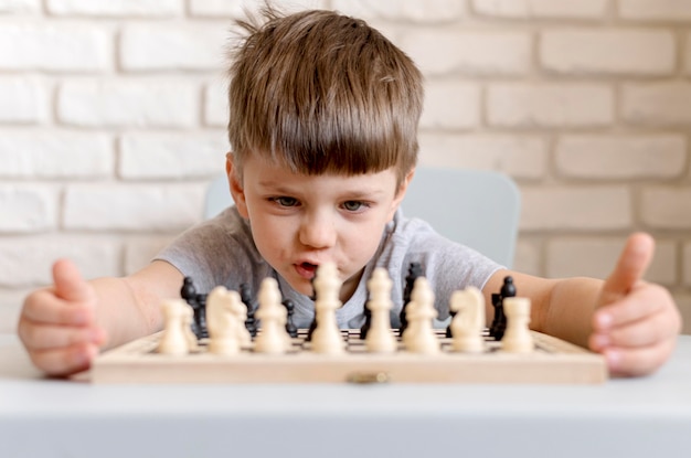 Tiro medio niño jugando al ajedrez