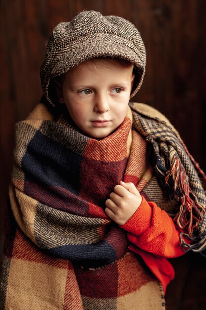 Tiro medio niño lindo con bufanda y sombrero