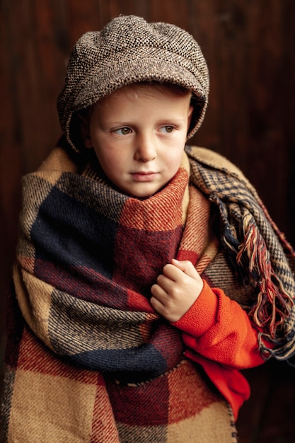 Tiro medio niño lindo con bufanda y sombrero