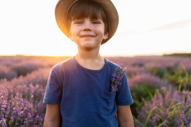 Tiro medio niño posando en campo de flores