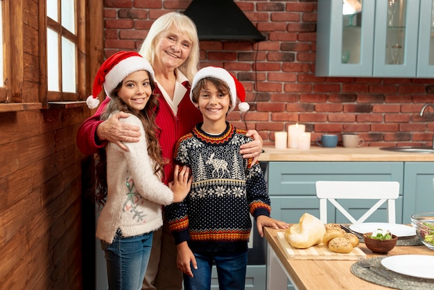 Foto gratuita tiro medio, niños y abuela posando en la cocina