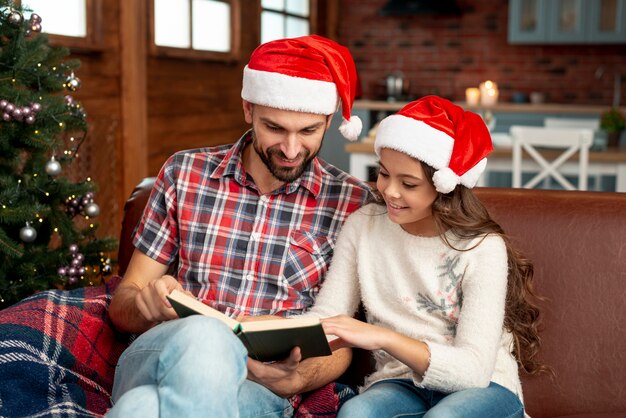 Tiro medio padre e hija leyendo juntos