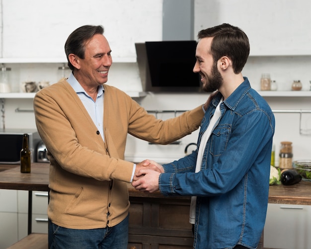 Tiro medio padre e hijo hablando en la cocina