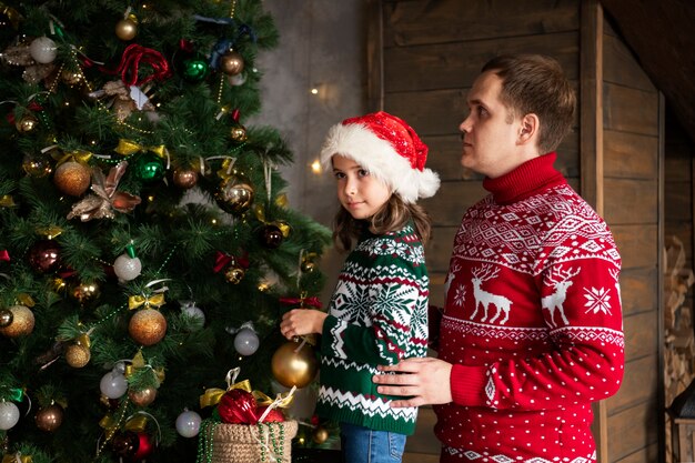 Tiro medio padre y niña en Navidad