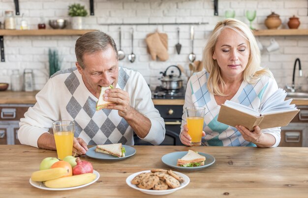 Tiro medio pareja en la cocina con libro