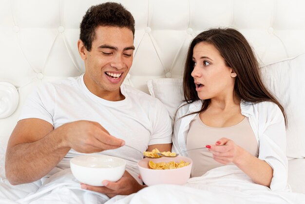 Tiro medio pareja comiendo cereales para el desayuno