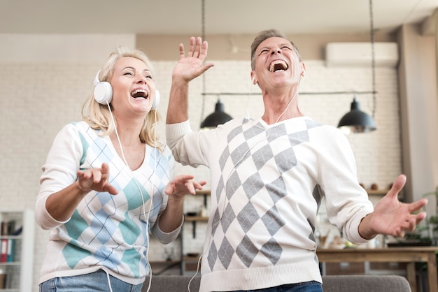 Tiro medio pareja divirtiéndose con auriculares