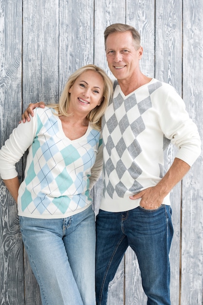 Foto gratuita tiro medio pareja feliz con fondo de madera