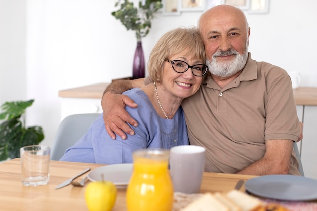 Foto gratuita tiro medio pareja sentada en la mesa